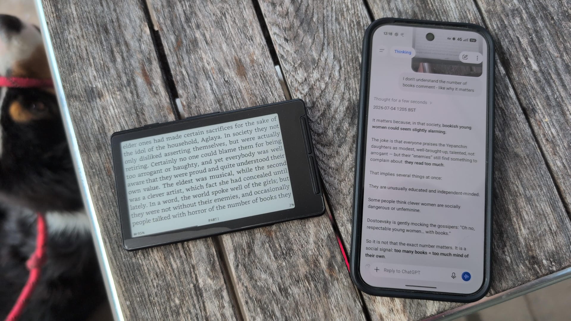 E-reader open on The Idiot beside a phone showing ChatGPT answering a question about the passage